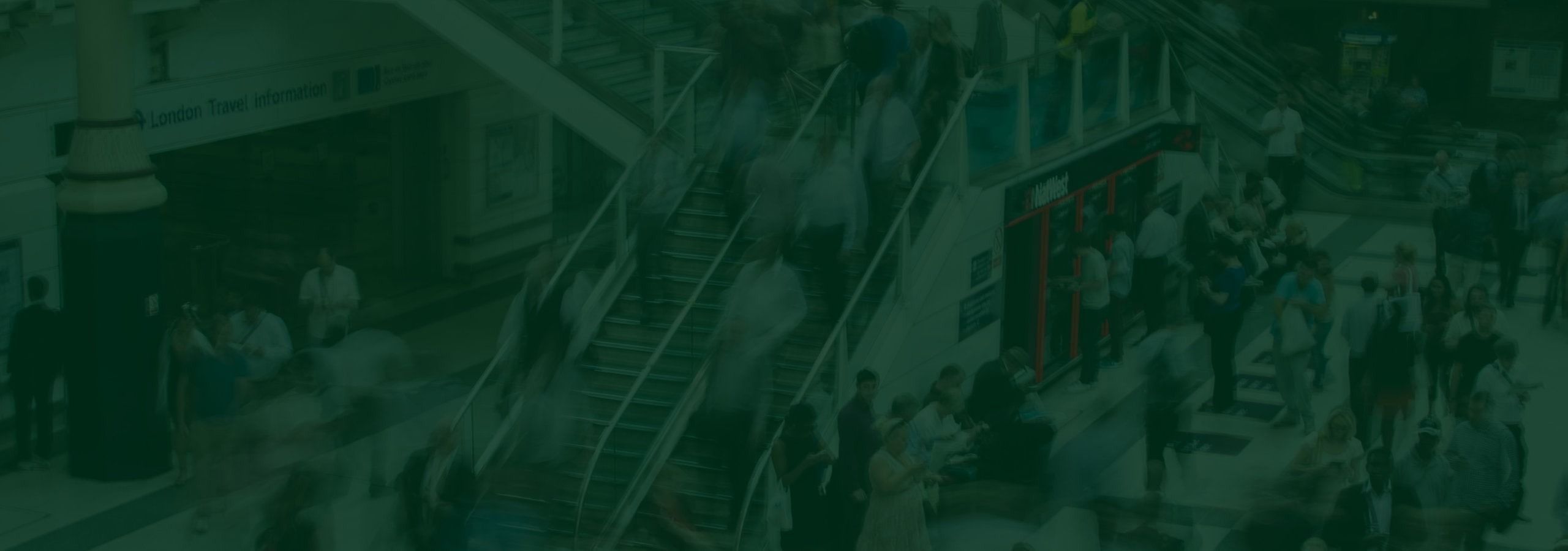 Menschen bewegen sich durch eine moderne Halle, als Bild für sichere und geordnete Meldewege in Organisationen.